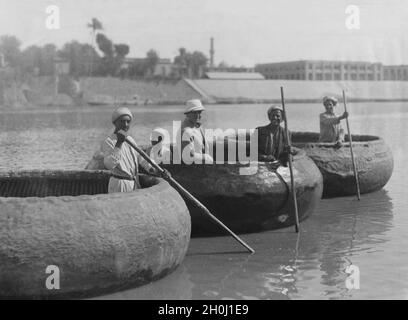 A European traveller with Iraqis in boats, as they are used by the population on the Euphrates and Tigris. They are woven from reeds, palm leaf strips and twigs and then covered with asphalt / tar to make them watertight. [automated translation] Stock Photo