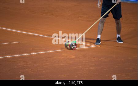 Man cleaning white lines on clay tennis court at national competition Stock Photo