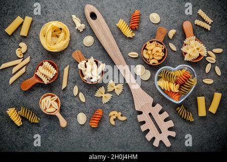 Italian foods concept and menu design. Various kind of Pasta Farfalle, Pasta A Riso, Orecchiette Pugliesi, Gnocco Sardo and Farfalle in wooden spoons Stock Photo