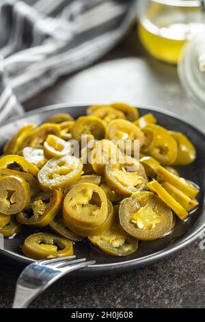 Pickled sliced jalapeno. Green jalapeno peppers on plate. Stock Photo