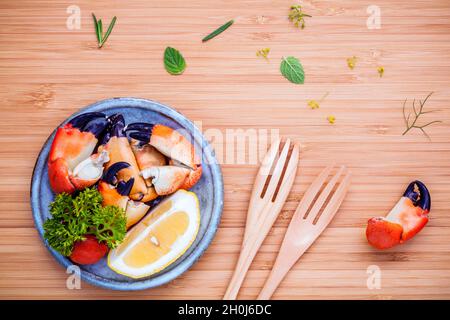 Fresh steamed red crabs leg in bowl . Red crabs leg with ingredients. Steamed red crabs leg with herbs Fennel ,parsley,rosemary,lemon and mint with fo Stock Photo