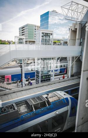 Rennes (Brittany, north western France): trains alongside the platforms in the railway station High speed trains and local trains with buildings in th Stock Photo