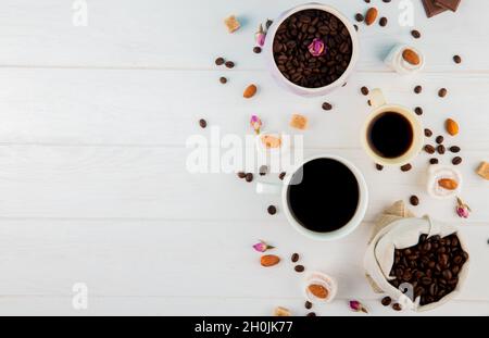 top view of coffee beans in a sack and cups of coffee on white background with copy space Stock Photo