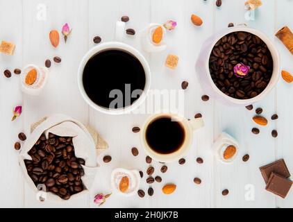 top view of coffee beans in a sack and cups of coffee on white background Stock Photo