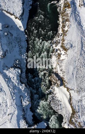 Aerial view of Godafoss waterfall, snowy shore and river. Iceland in early spring Stock Photo