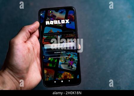 Barcelona, Spain - 13 october 2021: the Roblox app is seen on the screen of a mobile phone hold by hand. Roblox is an online metaverse app Stock Photo