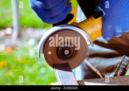 Industry worker cutting metal with grinder. Lots of glowing sparks. A construction worker using an angle grinder producing a lot of sparks Stock Photo