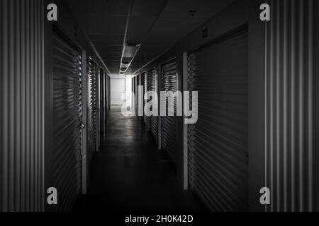 Light at end of dark hallway inside self storage center, New Jersey USA Stock Photo