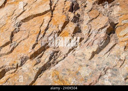 Raw rough yellow golden brown granite texture background. Natural rock stone texture background. Granite Grades. Muscovite colored minerals in granite Stock Photo