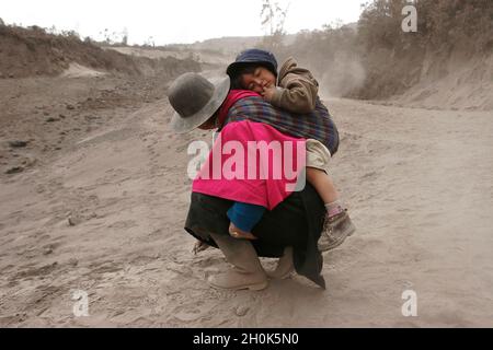 Survivors of a devastating volcanic eruption. The ‘Tungurahua’, an active volcano, in the ‘Cordillera Central’ (a chain of mountains, in the Andes) of Ecuador, erupted on July 14th and August 16th of 2006, devastating life in the small towns on its slope and surroundings. A “river of fire” was formed by over 10 million cubic meters of ash, gravel and incandescent material. More than 3000 people were evacuated from the area with six casualties and around 60 missing. With the alarm of another eruption ahead, the residents enter the emergency zone to work and take care of their homes. By nightfal Stock Photo