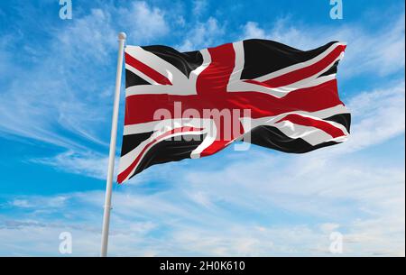 United Kingdom black and red flag at cloudy sky background on sunset. panoramic view. united kingdom of great Britain, England. copy space for wide ba Stock Photo