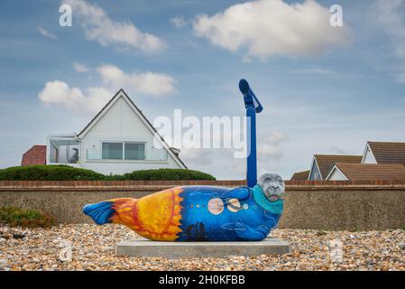 Colourful painted seal sculpture on the beach at Selsey, West Sussex, in memory of astronomer Sir Patrick Moore who lived there. Stock Photo
