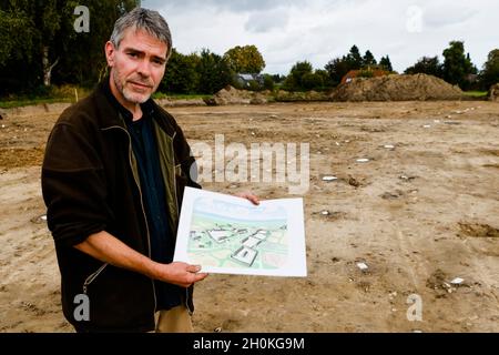 Taarstedt, Germany. 13th Oct, 2021. Ringo Clooß holds a drawing in his hands during excavations. During the development work for a new building area, the excavation manager of the State Archaeological Office and his colleagues had come across a settlement from the time around 500 AD. (to dpa 'Archaeologists find 1500 year old remains of a settlement') Credit: Frank Molter/dpa/Alamy Live News Stock Photo
