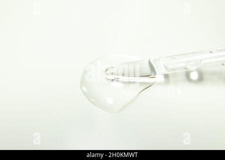 Drops from a pipette. Liquid gel or serum on a microscope screen on a white background Stock Photo