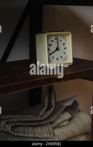 Closeup of an old classical clock on a wooden shelf Stock Photo