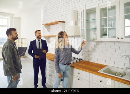 Couple planning to buy new home, meeting with realtor and looking around the house Stock Photo