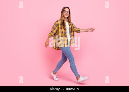 Full size profile portrait of positive satisfied girl walking look camera toothy smile isolated on pink color background Stock Photo