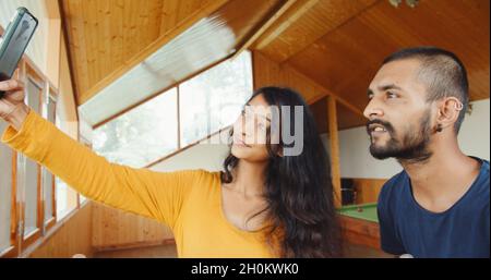 Beautiful young Indian couple taking a selfie with a phone Stock Photo