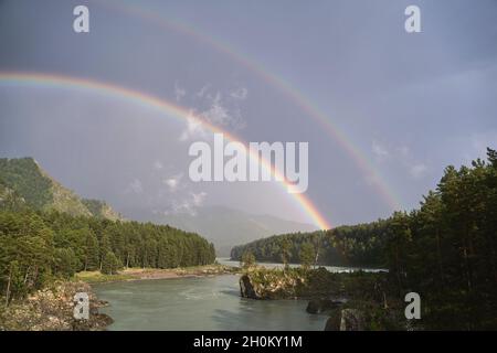Double rainbow. River and mountain landscape. Green trees. LGBT symbol Stock Photo