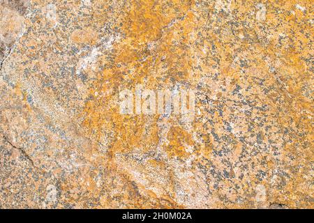 Raw rough yellow golden brown granite texture background. Natural rock stone texture background. Granite Grades. Muscovite colored minerals in granite Stock Photo