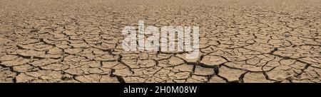 Panorama of cracked brown soil, barren wasteland surface natural background with deep focus Stock Photo