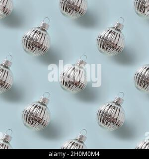 Seamless pattern of Christmas shiny silver baubles on blue background. Xmas abstract background. Stock Photo