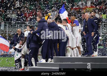 Milan, Italy, 10th October 2021. Didier Deschamps Head coach of France smiles and looks on as players and staff celebrate with the trophy following the 2-1 victory in the UEFA Nations League Final match at Stadio Giuseppe Meazza, Milan. Picture credit should read: Jonathan Moscrop / Sportimage Stock Photo