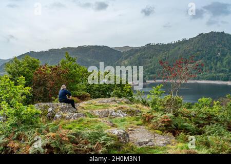 A mature male hiker admires view of Thirlmere reservoir in the English Lake District, UK Stock Photo
