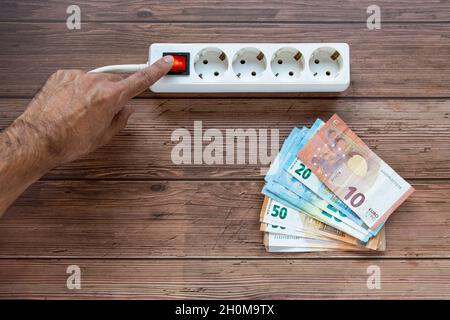 Man's hand pressing the power button on an extension cord Stock Photo