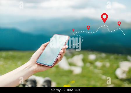 Woman hand using smart phone on top of mountain with navigator location point. Amazing Carpathians landscape background banner panorama with hills Stock Photo