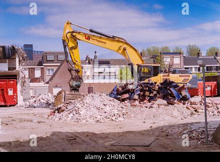 Tilburg, Netherlands. An earth- and debrea moving machine demolishing some real estate down town to make room for newly build apartments. Stock Photo