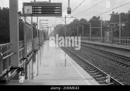 Rotterdam, Netherlands. A very rainy day at an elevated subway station's platform, where it should have been sunny and warm. Climate Change causes a huge increase in Rain and Storm at locations they can actually cause a lot of damage to, f.e. infrastructure. Collection: gkf-analoog Stock Photo