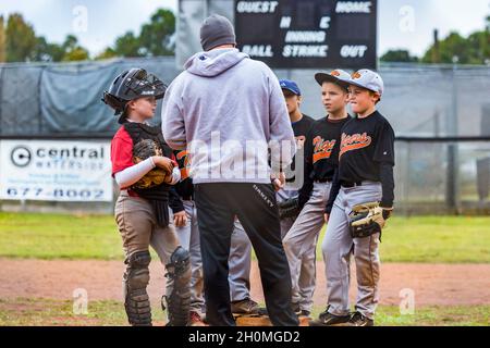 Youth baseball coach talks to team Stock Photo - Alamy