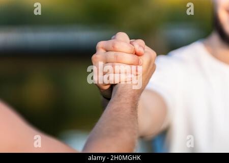 Close up view of two men shaking hands outdoors Stock Photo