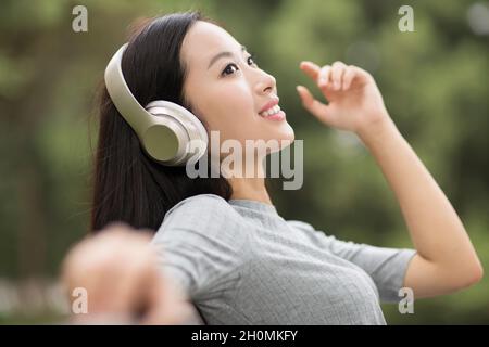 Cheerful young woman listening to music Stock Photo
