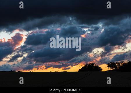 dramatic dark cloudscape in orange sky Stock Photo
