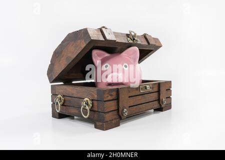 Toy piggy bank playing in old wood treasure chest. Stock Photo