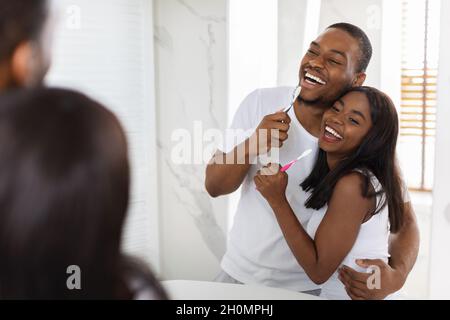 Cheerful African American Couple Having Fun While Brushing Teeth In Bathroom Together Stock Photo