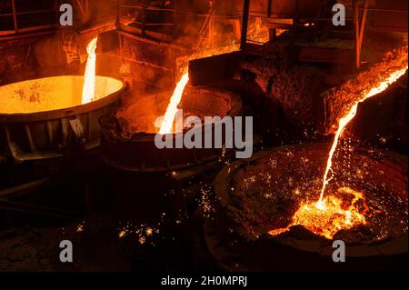 Blast furnace slag and pig iron tapping. Molten metal and slag are poured into a ladle. Stock Photo