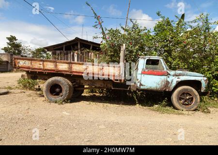 Pilcopata, Peru - April 12, 2014: An old, rusty and abandoned Ford truck, painted blue, rests in the surroundings of the small town of Pilcopata Stock Photo