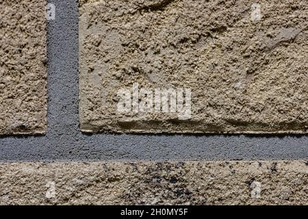 Close-up texture of a brown scratched brick wall with a gray seam Stock Photo
