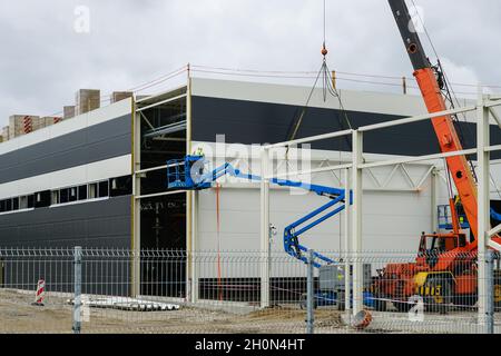 a sandwich panel wall mounting with the help of a modern telescopic crane and mobile self propelled hydraulic lifting platform Stock Photo