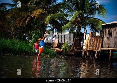 The Sinamaica lagoon is a large extension of water located northwest of Zulia state, Venezuela. The Sinamacia village inhabited by the ethnic Añu Indians is one of the last floating villages on earth. They have been living in the area in houses above water known as palafitos, since pre-colonial times. They use the water body for fishing, transport, and other activities. Wooden canoes or small motor boats are used for transportation. Life in the lagoon is currently threatened by social issues such as severe poverty, water contamination and global warming. Bolivian Republic of Venezuela. March 3 Stock Photo