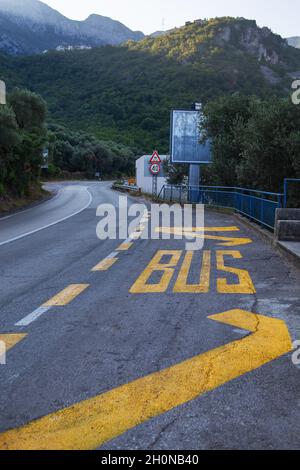 The inscription BUS in bright yellow paint, painted on the asphalt road Stock Photo