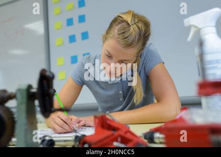 pretty student writing notes in classroom thinking Stock Photo