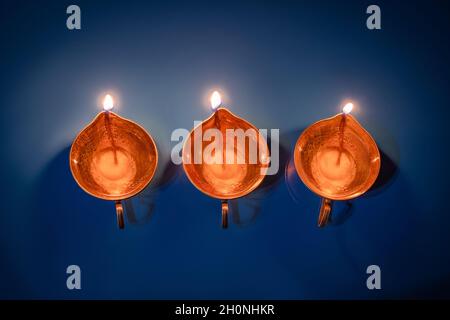 Happy Diwali. Diya on blue background. Traditional oil lamp. Celebrating festival of light. Copy space. Stock Photo