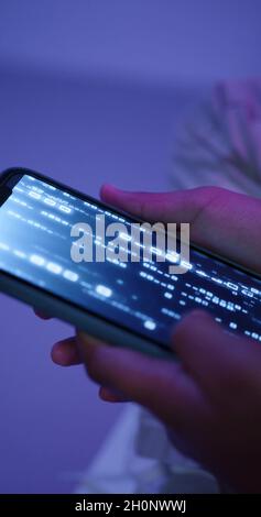 A smartphone in the hands of a hacker Stock Photo