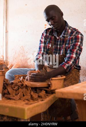 African ceramist working at a pottery wheel in a studio Stock Photo - Alamy