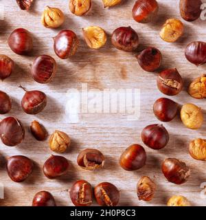 Chestnuts, square overhead flat lay shot on a rustic wooden background with copy space Stock Photo