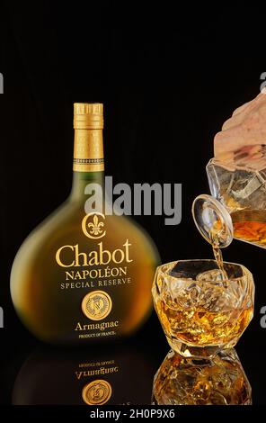 Tel Aviv, Israel - September 28, 2021: Armagnac Chabot, a special reserve of Napoleon made in France, pours from decanter into glass. Stock Photo